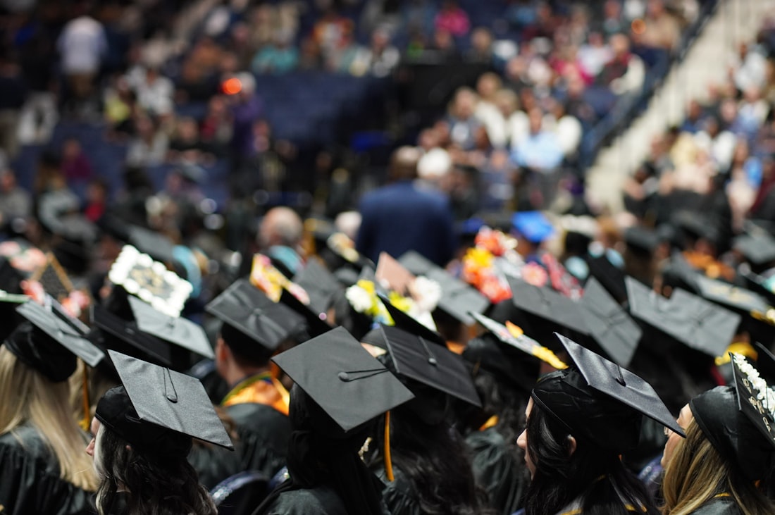Graduates in caps and gowns seated at a commencement ceremony