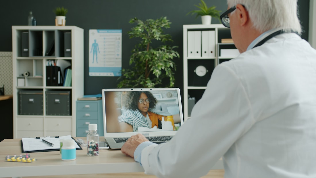 A clinician on a telehealth video call on a laptop