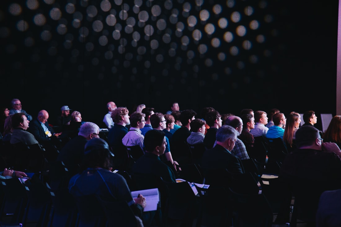 A large staff audience seated at an all-hands meeting